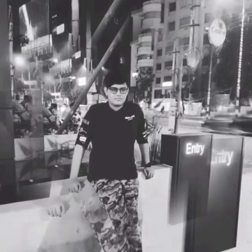A Man In A Black Shirt Stands In Front Of A Sign That Says Entry GIF