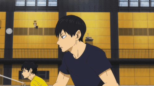 A Man In A Black Shirt Stands Next To A Man In A Yellow Shirt GIF