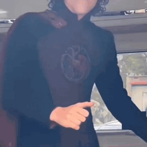 A Man In A Black Shirt With A Dragon On It GIF