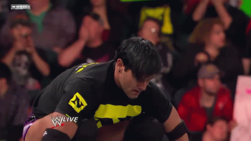 A Man In A Black Shirt With A Yellow Letter N On It GIF