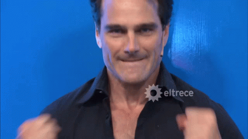 A Man In A Black Shirt With Eltrece On The Bottom Right GIF