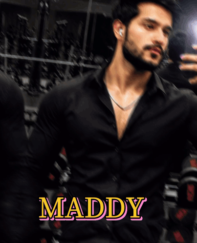 A Man In A Black Shirt With The Name Maddy On The Bottom Right GIF
