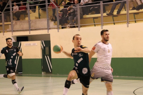 A Man In A Black Shirt With The Word Gaban On It Is Holding A Ball GIF
