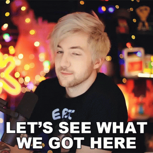 A Man In A Black Shirt With The Words Let 'S See What We Got Here On The Bottom GIF
