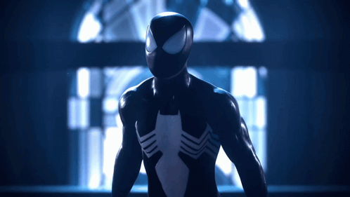 A Man In A Black Spiderman Suit Stands In A Dark Room GIF