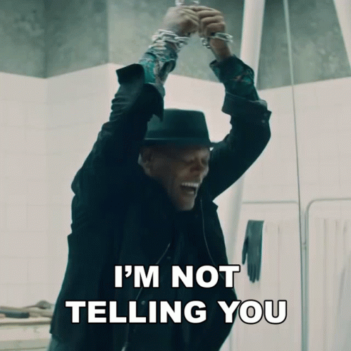 A Man In A Black Suit And Hat Says I 'M Not Telling You While Holding Up His Hands GIF