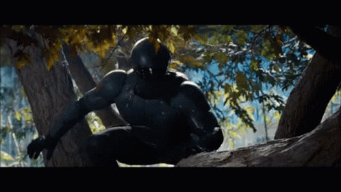A Man In A Black Suit And Helmet Is Climbing A Tree GIF