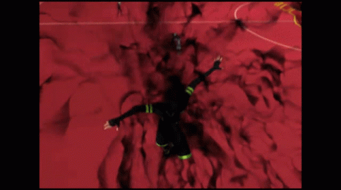 A Man In A Black Suit Is Flying Through A Red Room With A Sign That Says G-Z GIF