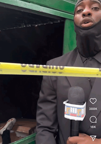 A Man In A Black Suit Is Holding A Microphone With A Lanyard That Says ' Mtn Radio ' On It GIF