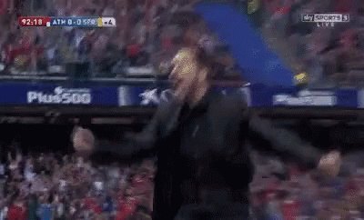 A Man In A Black Suit Is Screaming In A Dark Room While Watching A Sports Game On Sky Sports GIF