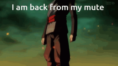 A Man In A Black Suit Is Standing In Front Of A Green Background With The Words I Am Back From My Mute GIF