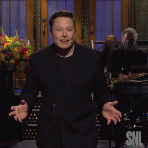 a man in a black suit is standing in front of a snl sign