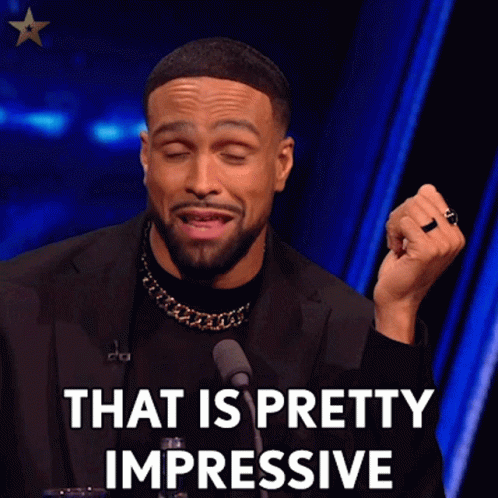 A Man In A Black Suit Is Talking Into A Microphone And Saying That Is Pretty Impressive GIF