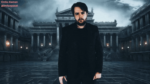 A Man In A Black Suit Stands In Front Of A Building With The Name Emilia At The Top GIF