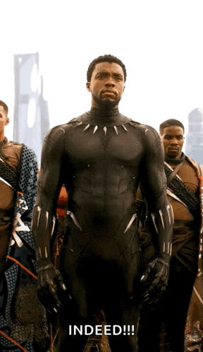 A Man In A Black Suit Stands In Front Of A Group Of Men And The Word Indeed Is Written Below Him GIF