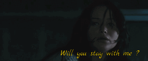 A Man In A Black Suit Stands In Front Of A Window GIF