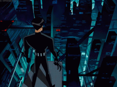 A Man In A Black Suit Stands On A Balcony Overlooking A City At Night GIF