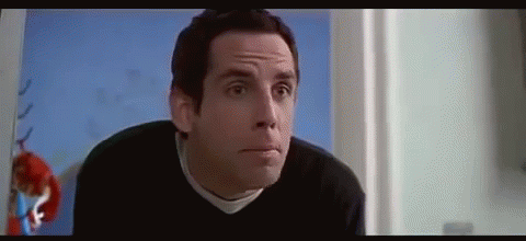 A Man In A Black Sweater Is Making A Funny Face In A Room . GIF
