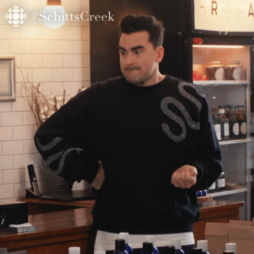 A Man In A Black Sweater With The Word Schitts Creek On It GIF