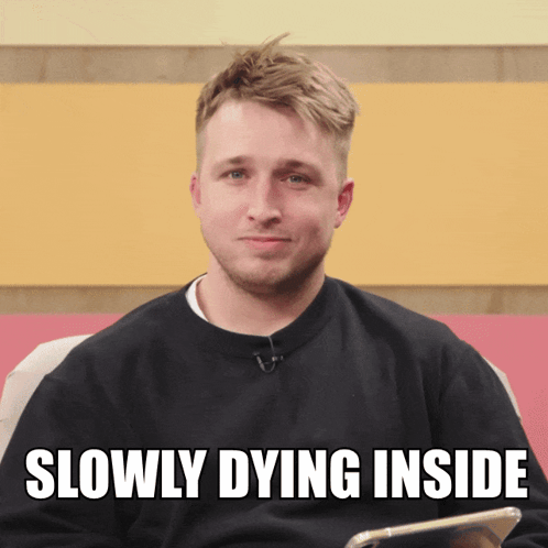 A Man In A Black Sweater With The Words Slowly Dying Inside Above Him GIF
