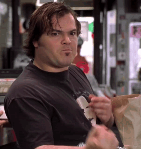 A Man In A Black T-Shirt Is Eating A Bag Of Chips GIF