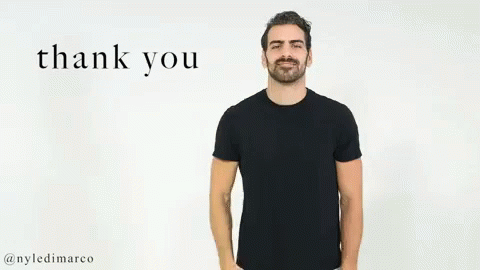 A Man In A Black T-Shirt Is Giving A Thank You Gesture With His Hand . GIF