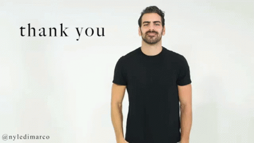 A Man In A Black T-Shirt Is Giving A Thank You Gesture With His Hand . GIF