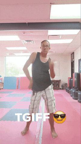 A Man In A Black Tank Top And Plaid Shorts Is Dancing In A Gym With The Words Tgiff Behind Him GIF