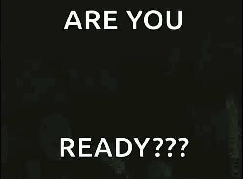 A Man In A Black Tank Top Is Holding A Sign That Says Are You Ready GIF