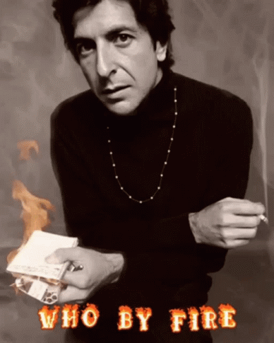 A Man In A Black Turtleneck Is Holding A Cigarette And A Piece Of Paper With The Words Who By Fire Above Him GIF