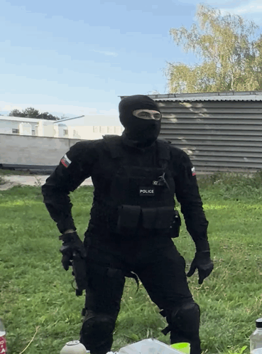 A Man In A Black Uniform With The Word Police On His Chest GIF