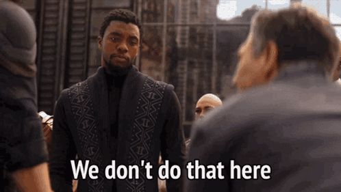 A Man In A Black Vest Is Standing In Front Of A Group Of Men And Saying We Don 'T Do That Here . GIF