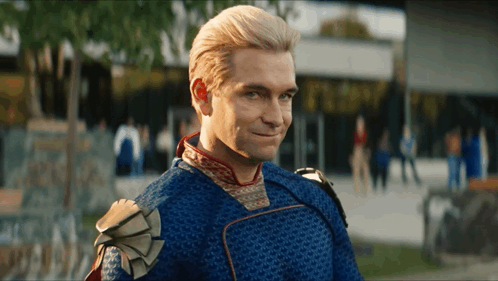 A Man In A Blue And Gold Superhero Costume Is Smiling GIF