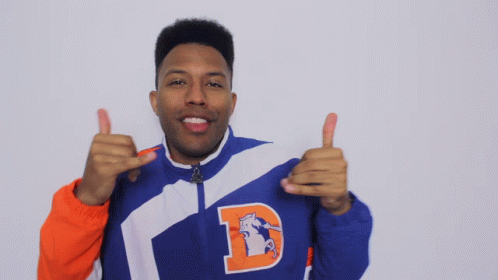 A Man In A Blue And Orange Jacket With The Letter D On It GIF