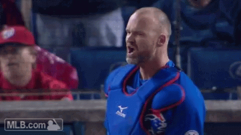 A Man In A Blue And Red Baseball Uniform Is Standing In Front Of A Mlb.com Logo GIF