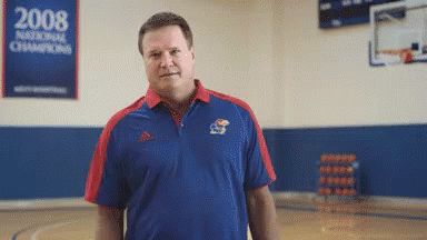 A Man In A Blue And Red Shirt Is Standing In Front Of A 2008 National Champions Sign GIF