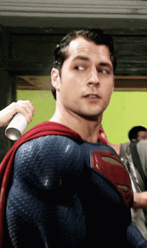 A Man In A Blue And Red Superman Costume GIF
