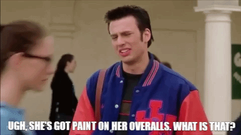 A Man In A Blue And Red Varsity Jacket Is Talking To A Woman In A Hallway . GIF