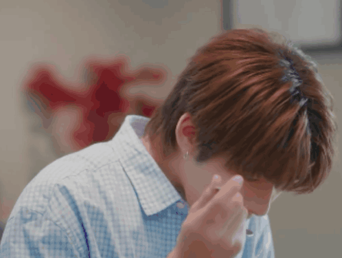 A Man In A Blue And White Checkered Shirt Wipes His Nose GIF