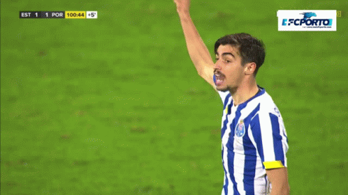 a man in a blue and white striped shirt holds up his fist