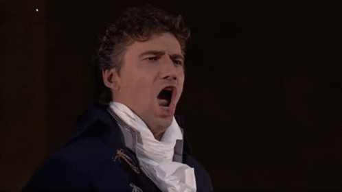 A Man In A Blue Coat And White Scarf Is Yawning . GIF