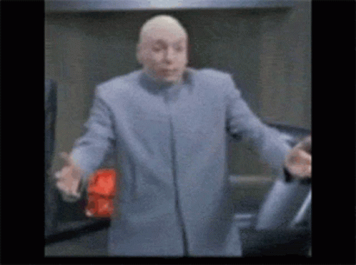 Man In Blue Coat Stands In Front Of Car With Outstretched Arms GIF
