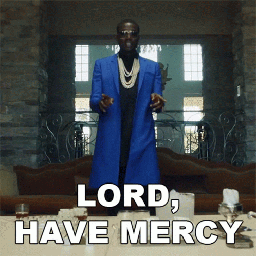 A Man In A Blue Coat Stands In Front Of A Table With The Words Lord Have Mercy On It GIF
