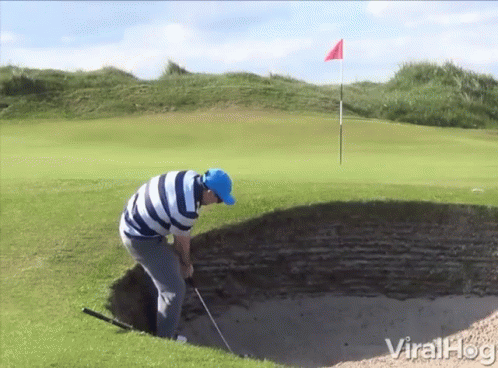A Man In A Blue Hat Is Playing Golf On A Golf Course GIF
