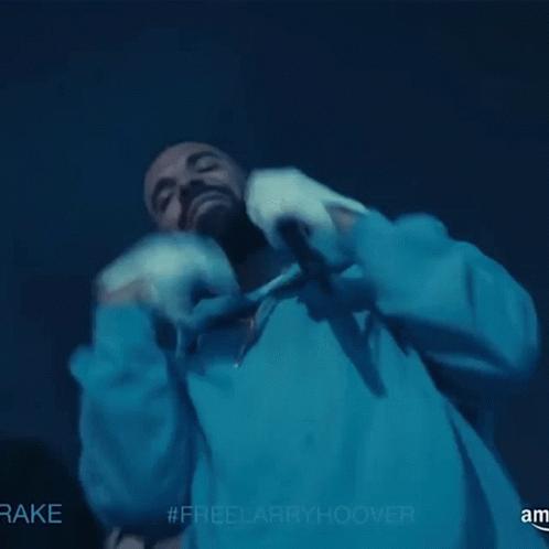A Man In A Blue Hoodie Is Holding A Microphone With The Hashtag #Freelarryhoover On The Bottom GIF