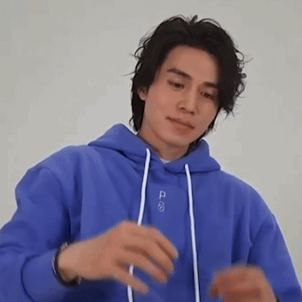 a man in a blue hoodie is making a funny face .