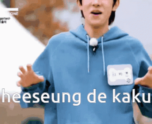 A Man In A Blue Hoodie With A Name Tag That Says Heeseung De Kaki On It GIF