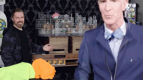 A Man In A Blue Jacket And Bow Tie Is Standing Next To Another Man GIF