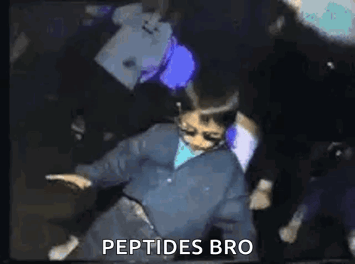 a man in a blue jacket is dancing in a dark room with the words `` peptides bro '' written on the bottom .