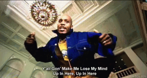 A Man In A Blue Jacket Is Dancing In A Room With A Chandelier In The Background GIF
